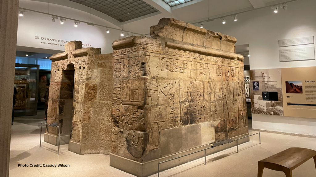 Interior of the Ancient Egypt exhibition room at the Ashmolean Museum, featuring a large stone tomb engraved with petroglyph drawings.