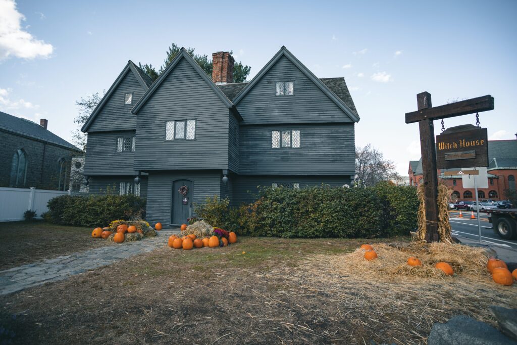 The Witch House in Salem, Massachusetts on a stormy day with pumpkins displayed out front.